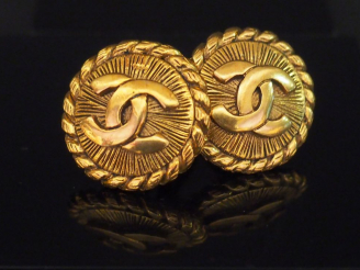 Vente aux enchères CHANEL. Paire de clips d'oreilles en métal doré.
