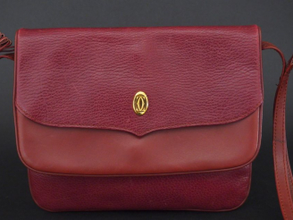 Vente aux enchères MUST DE CARTIER. Pochette en cuir marron H. 19 cm