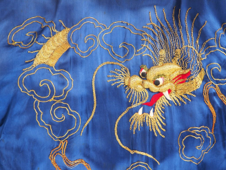 Vente aux enchères Indochine, vers 1930, Robe en soie bleue à décor de dragons. (quelques