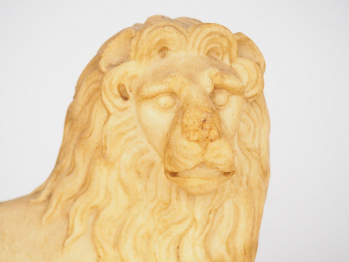 Paire de lions en albâtre sculpté en ronde-bosse. Couchés, les antérie
