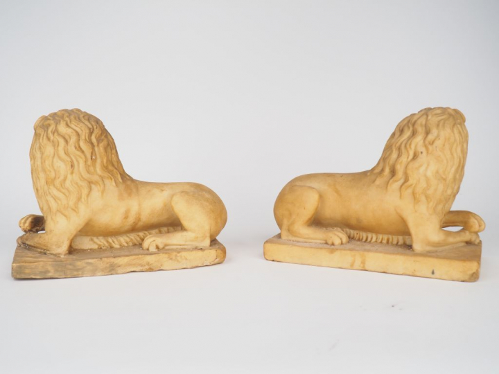 Paire de lions en albâtre sculpté en ronde-bosse. Couchés, les antérie