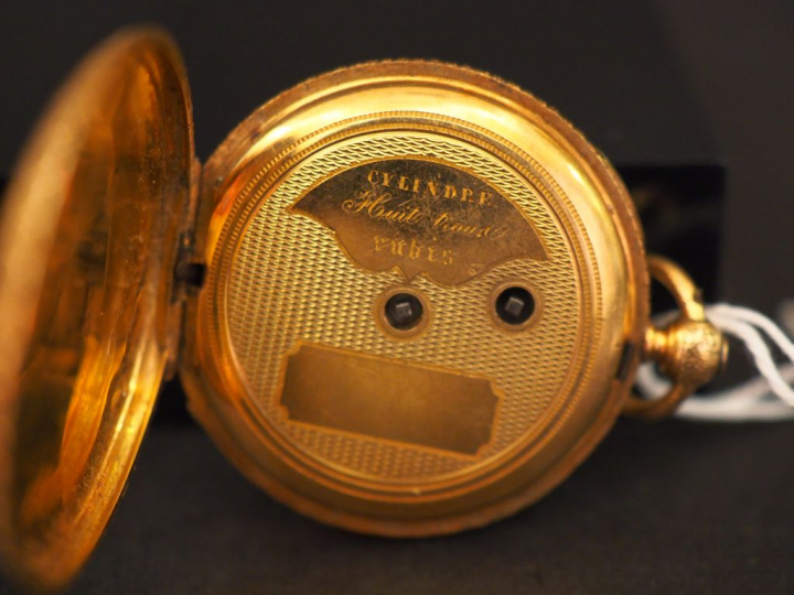 Montre de col en or jaune et émail noir. Le revers à décor de monogram