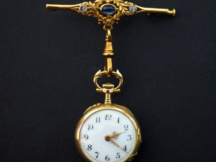 	Montre de col et sa broche en or jaune.  La broche, à décor de couron