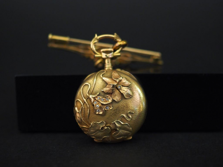 	Montre de col et sa broche en or jaune.  La broche, à décor de couron