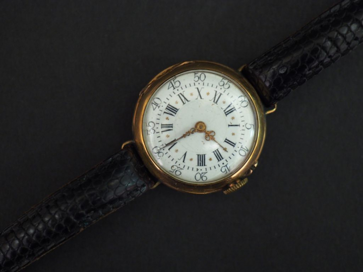 Montre bracelet, boitier en or jaune. Le revers, à décor de monogramme