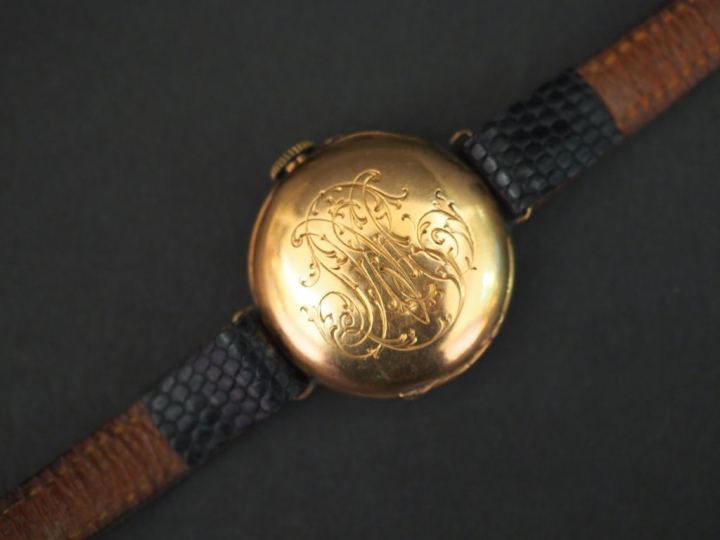Montre bracelet, boitier en or jaune. Le revers, à décor de monogramme