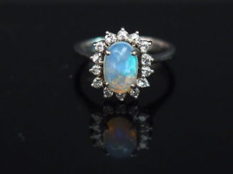 Vente aux enchères 	Petite bague marguerite en or blanc 14K, sertie en son centre d’une o