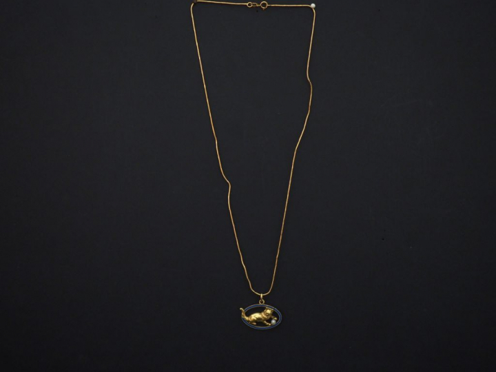 	Pendentif et sa chaine en or jaune, perle et émail bleu figurant un c