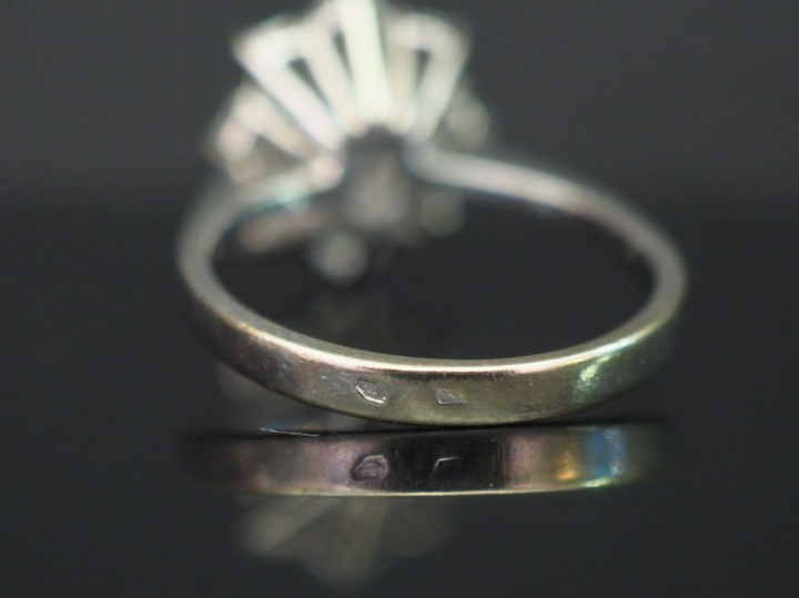 Bague marguerite en or blanc, sertie en son centre d’un saphir entouré