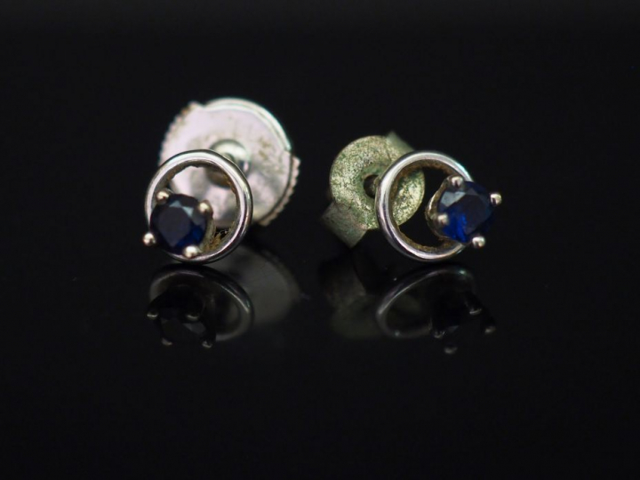Paire de puces d’oreilles en or blanc, serties d’un petit saphir. Poid
