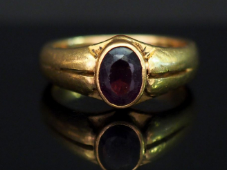 Vente aux enchères Bague jonc en or jaune, sertie en son centre d’une pierre rouge. TDD. 