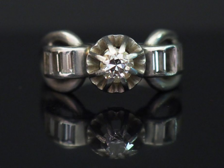Bague de style 1900 en or blanc, sertie en son centre d’un diamant tai