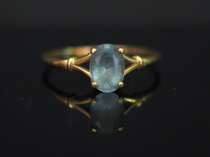	Petite bague en or jaune, sertie en son centre d’une pierre bleue. TD