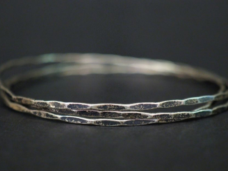 Vente aux enchères 	Trois joncs facettés assortis en argent. Diam. 6,5 cm Poids. 9,63 g