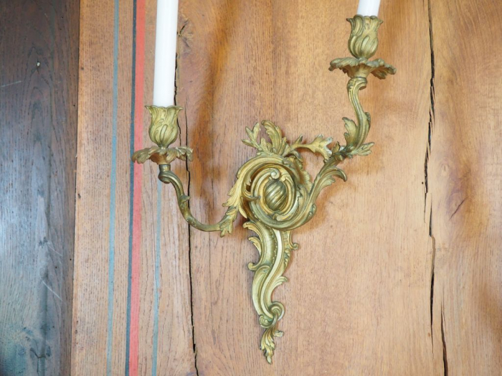 Suite de quatre appliques de style Rocaille en bronze, éclairant à 2 l