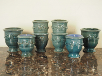 Vente aux enchères Suite de 8 petits pots en terre vernissée bleu.