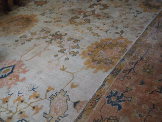Vente aux enchères Grand tapis en laine à fond clair (mauvais état). Dim. 657 x 360 cm.