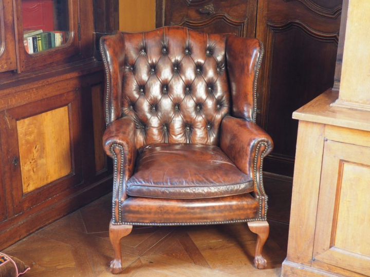 Paire de fauteuils anglais garniture de cuir brun capitonné. Dim. 102 