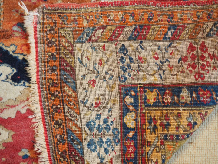 Tapis d'Orient ancien en laine fond rouge. Dim. 313 x 44 cm.