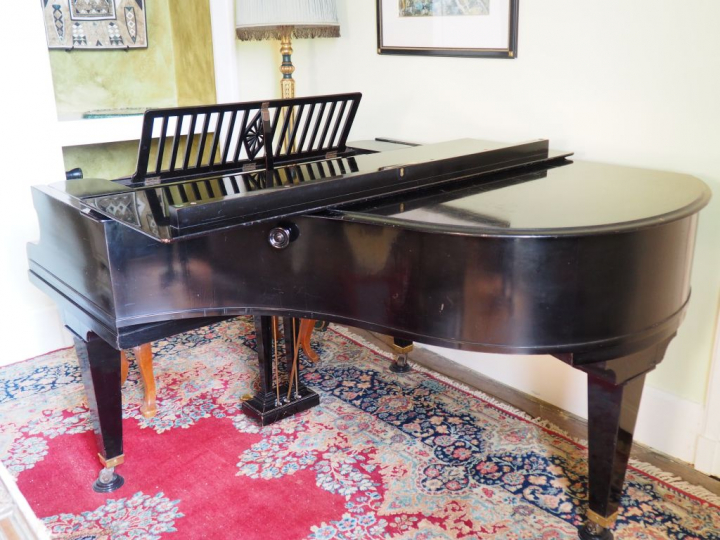 Piano quart de queue Berchstein en bois laqué noir cadre fer.