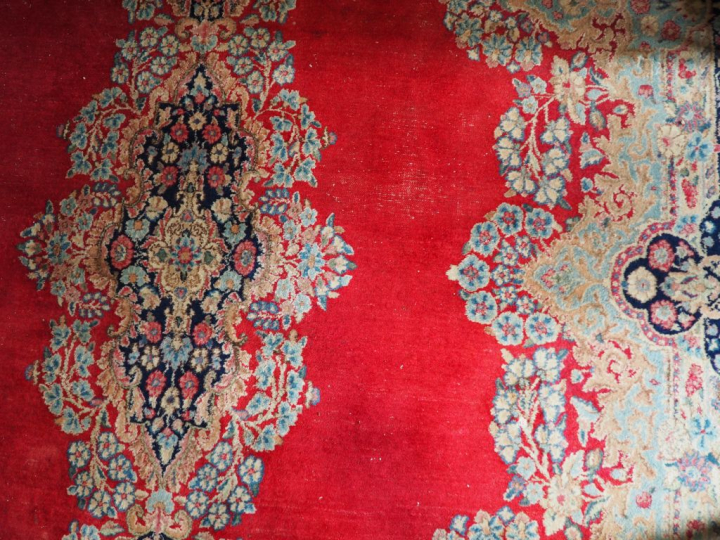 Grand tapis d'Orient à fond rouge ancien.