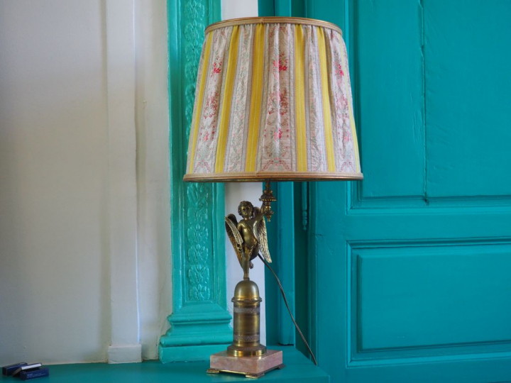 Lampe de style Empire en bronze et marbre à décor d'un angelot. H. 70 