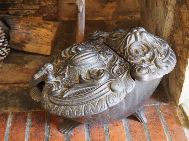 Pot à cendres en fonte XIXème à décor d'un blason et de rinceaux. Dim 