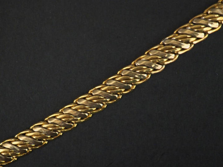 Bracelet articulé deux tons d'or, maille tressée.  Long. 19,5 cm Poids