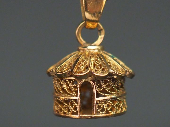 Pendentif en or jaune en forme de case, à décor de filigranes. H. 1,1 
