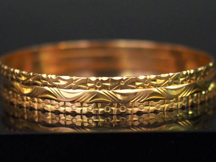 Trois bracelets jonc en or jaune, à décor de frises de fleurs, motifs 