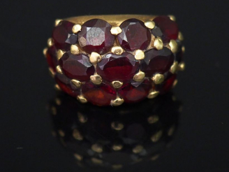 Vente aux enchères 	Bague dôme en or jaune et pavage de grenats. TDD. 56 Poids tel. 9,01 
