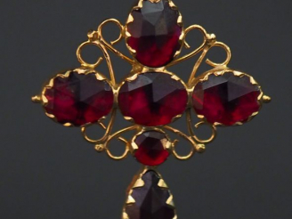 Vente aux enchères 	Pendentif en forme de croix en or jaune, serti de six grenats, décor 