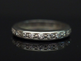 Vente aux enchères 	Alliance américaine en platine, sertie de petits diamants. TDD. 50 Po