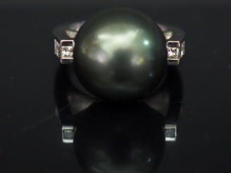 Vente aux enchères 	Bague moderne en or blanc, sertie d’une perle grise de Tahiti.  La mo