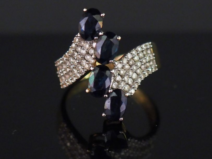 Bague moderne en or jaune, sertie en son centre de quatre saphirs.  Mo