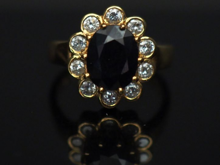 	Bague marguerite en or jaune, sertie en son centre d’un saphir entour