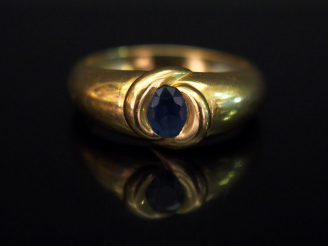 Vente aux enchères 	Bague jonc en or jaune, sertie d’une pierre bleue. TDD. 54 Poids tel.