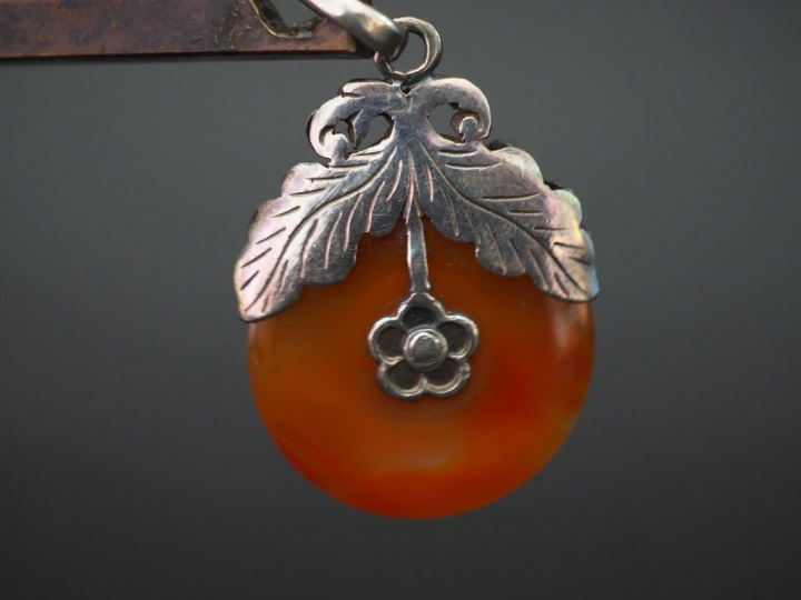 Pendentif en argent et cornaline, à décor double faces de fleur. Long.