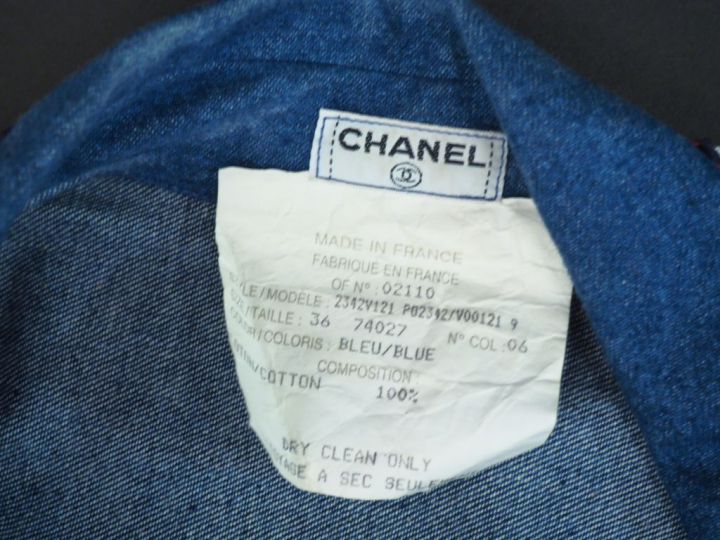 	CHANEL Veste sans manche à col en coton, à décor d’un galon bleu, bla