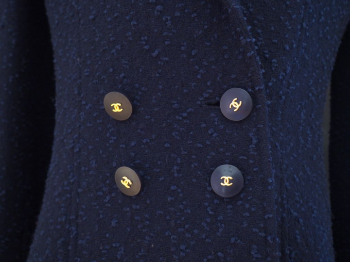 CHANEL Veste courte à col bleu marine. Deux poches au niveau de la poi