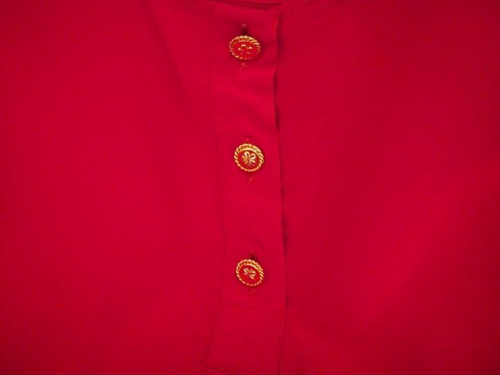 	CHANEL Débardeur rouge.  Ouverture à l’avant par trois boutons dorés.