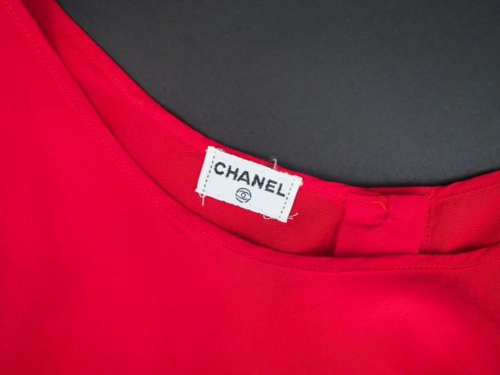 	CHANEL Débardeur rouge.  Ouverture à l’avant par trois boutons dorés.