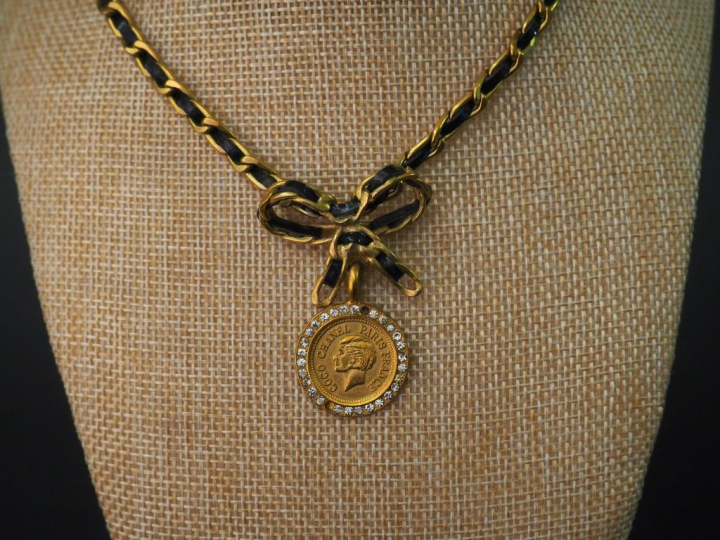 CHANEL Parure en métal doré entrelacé de cuir noir. Comprenant : - un 