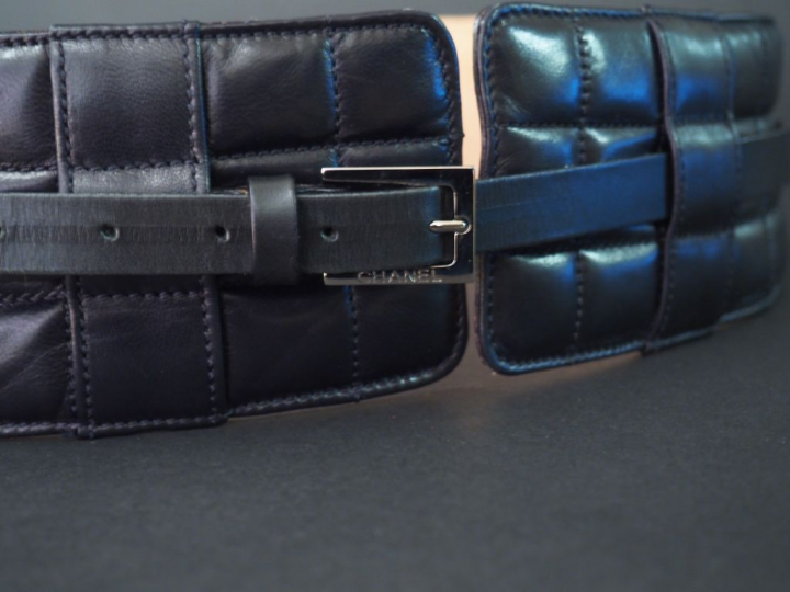 	CHANEL Large ceinture en cuir noir molletonné. Boucle en métal argent