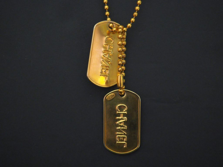 	CHANEL Sautoir en métal doré, à décor de boules retenant deux plaques