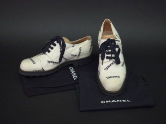 Vente aux enchères 	CHANEL Paire de richelieus en tissu blanc, à décor en noir du nom de 