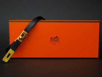 Vente aux enchères HERMES, Paris. Collier en cuir noir et métal doré, modèle « Kelly ». S