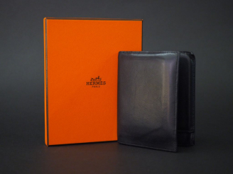 Vente aux enchères 	HERMES, Paris. Portefeuilles en cuir noir.  Signé. 12 x 9.4 cm  Dans 