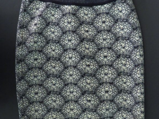 Vente aux enchères ALAÏA. Mini jupe en maille dans les tons noir et blanc, à décor de fle