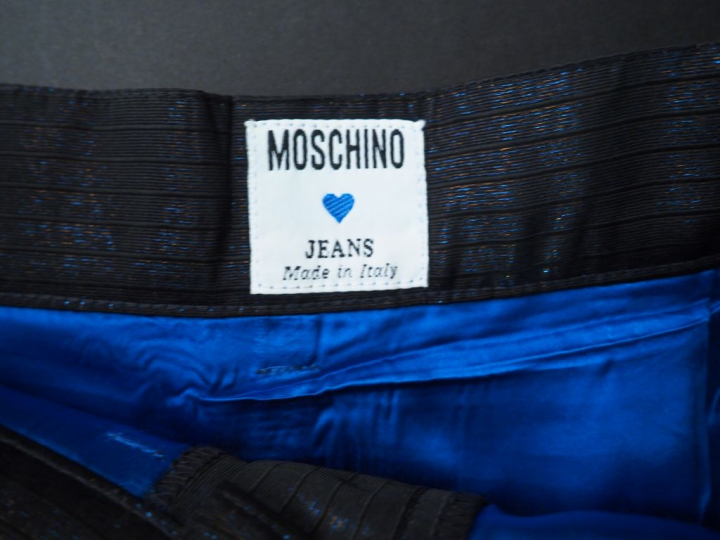 MOSCHINO.  Jupe en tissu noir brillant. Trois poches à l’avant et deux
